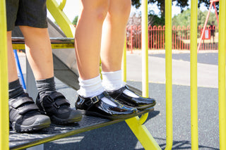 a boy & a girl wearing black school shoes